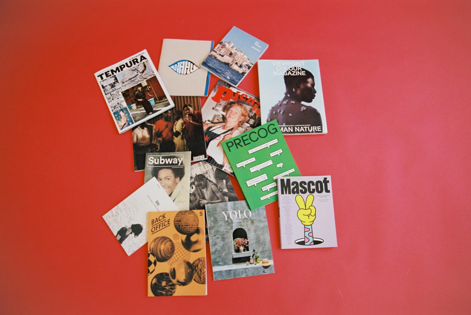 Independent magazines laid out on a red backdrop
