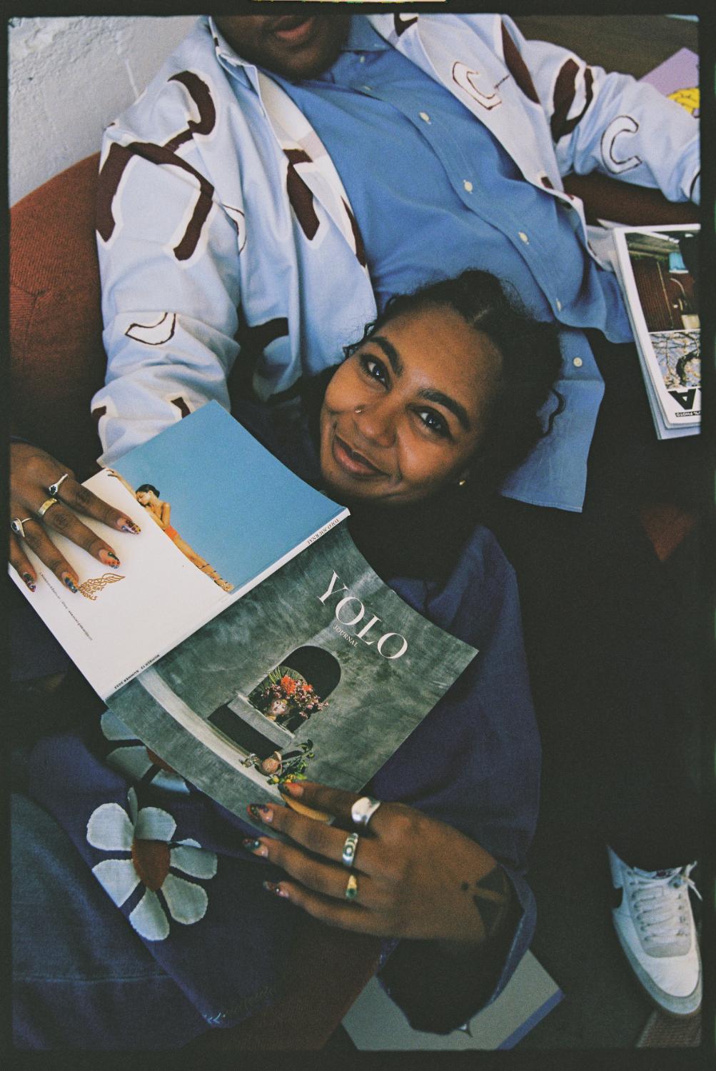 A reader holding YOLO magazine on a couch